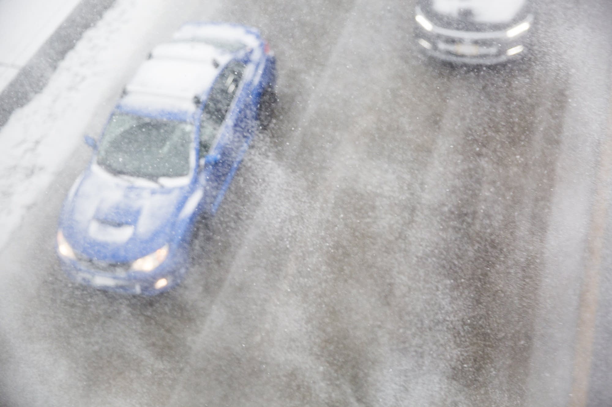 Cars cut through blowing snow on highway 35W
