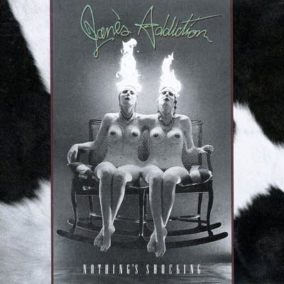 Two nude figures sitting in a rocking chair, their hair ablaze