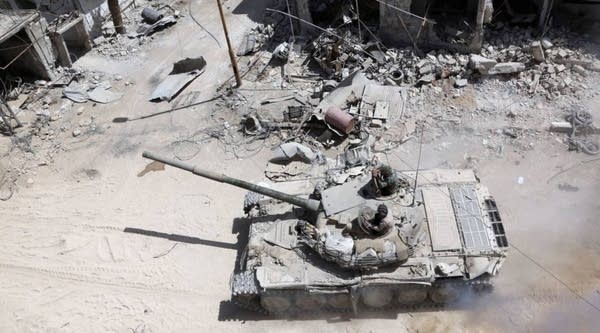 A picture taken on Sunday shows Syrian Army soldiers advancing in an area on the eastern outskirts of Douma, as they continue their fierce offensive to retake the last opposition holdout in Eastern Ghouta.