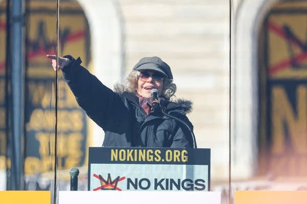 A woman speaks and raises her hand to talk