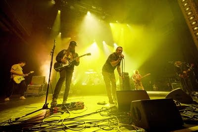 A band performing onstage in a large music venue 