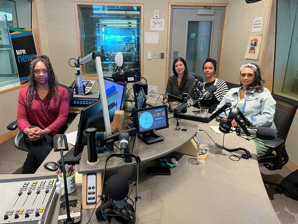 four women posing in a broadcast studio