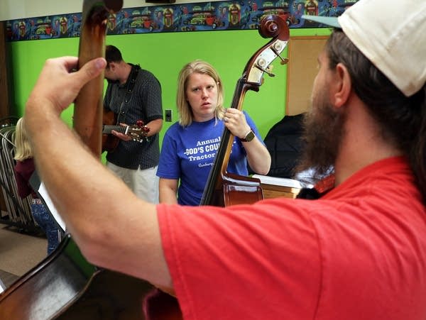 a man and a woman play stringed instruments