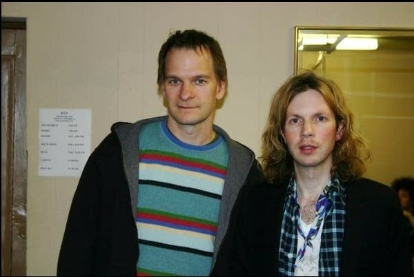 Two men pose for a photograph