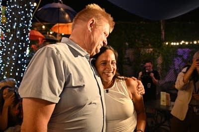 A man and woman hug in a crowd.