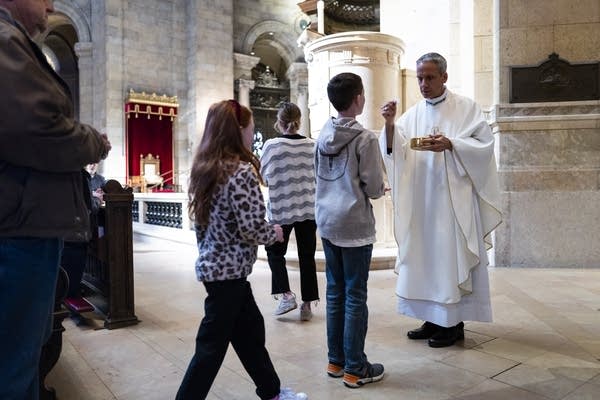 A clergy member delivers communion