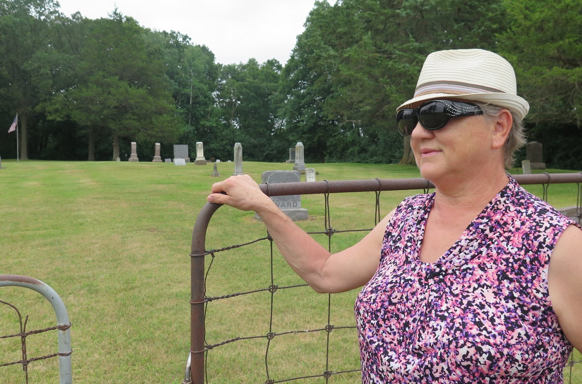 Janet Klug, niece of Elmer Kerestes, stands at the gate of the cemetery.