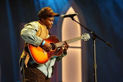 A musician plays guitar onstage