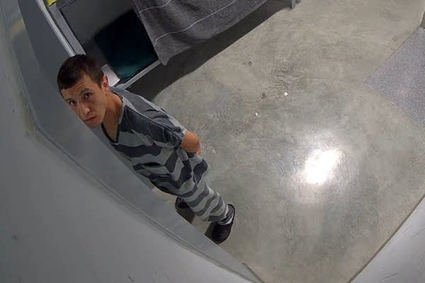 man in ice detention looks at camera