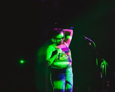A musician sings and gestures during on onstage performance