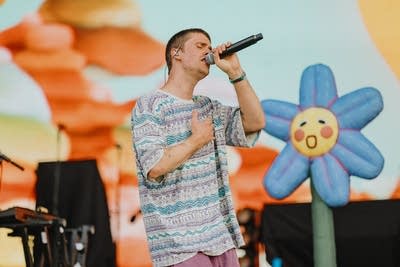 A musician sings on a large outdoor stage