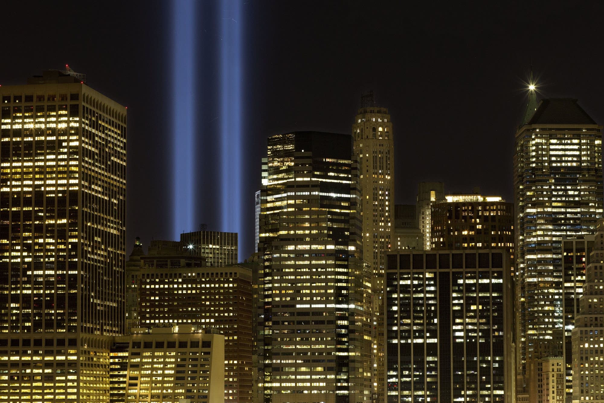The Tribute in Light rises above the lower Manhattan skyline.