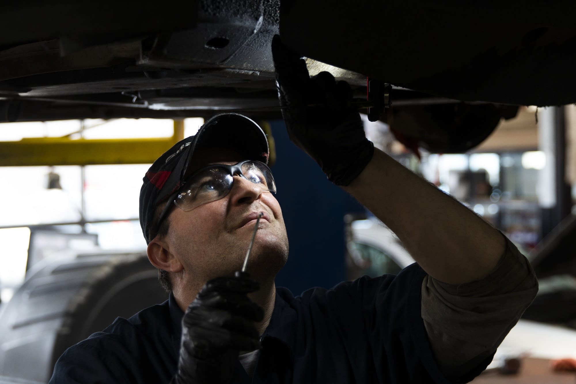 Auto technician John Buttner inspects a car inside Lift Garage.