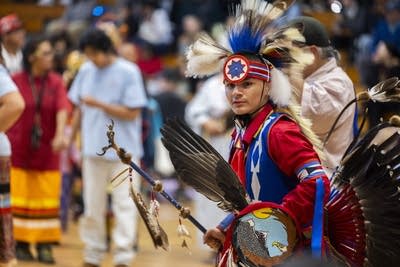 A young man dances in a gymnasium for Indigenous Peoples Day.