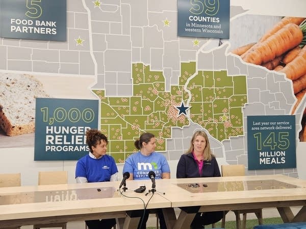 Three women sit behind a table