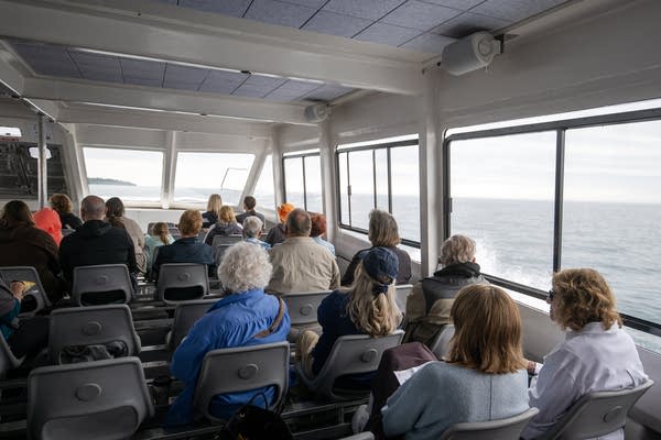 People look out windows in a cruise
