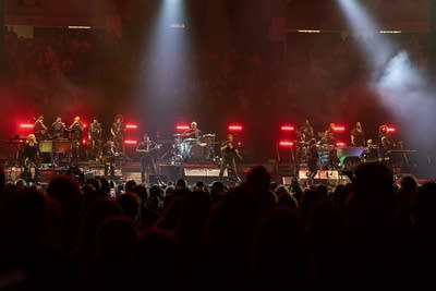 A band performing onstage during a concert in an arena