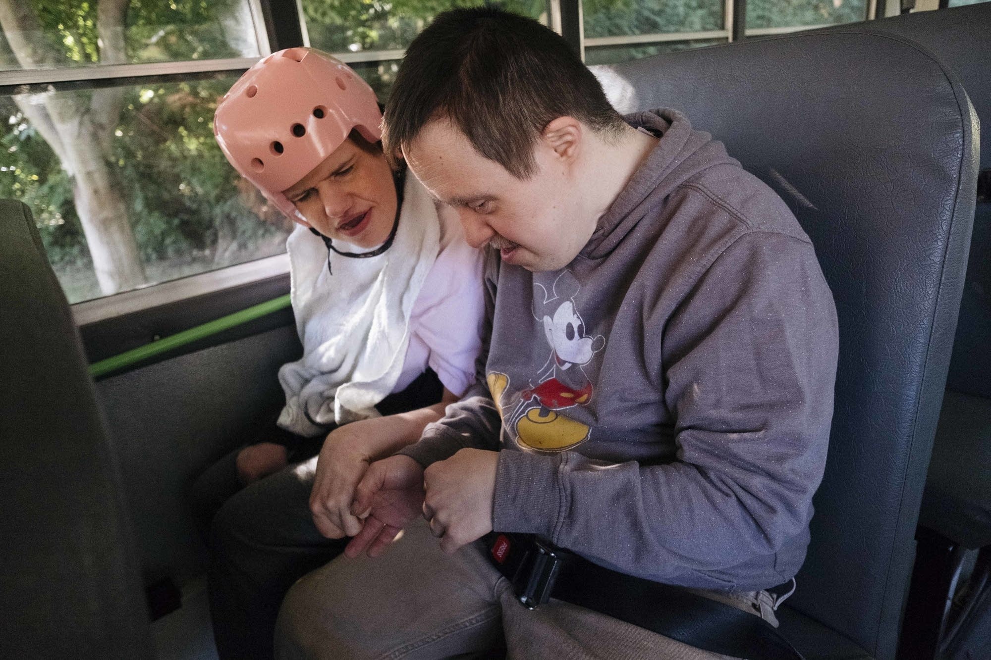 Sarah and David hold hands on the bus to work.