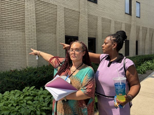 Two people pointing at a building