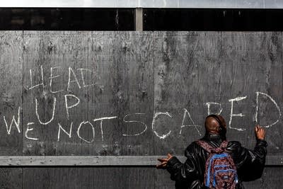 A man draws on a wall in chalk.