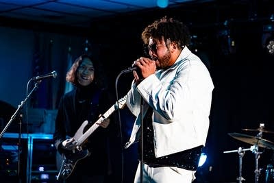 A musician sings onstage in a music venue