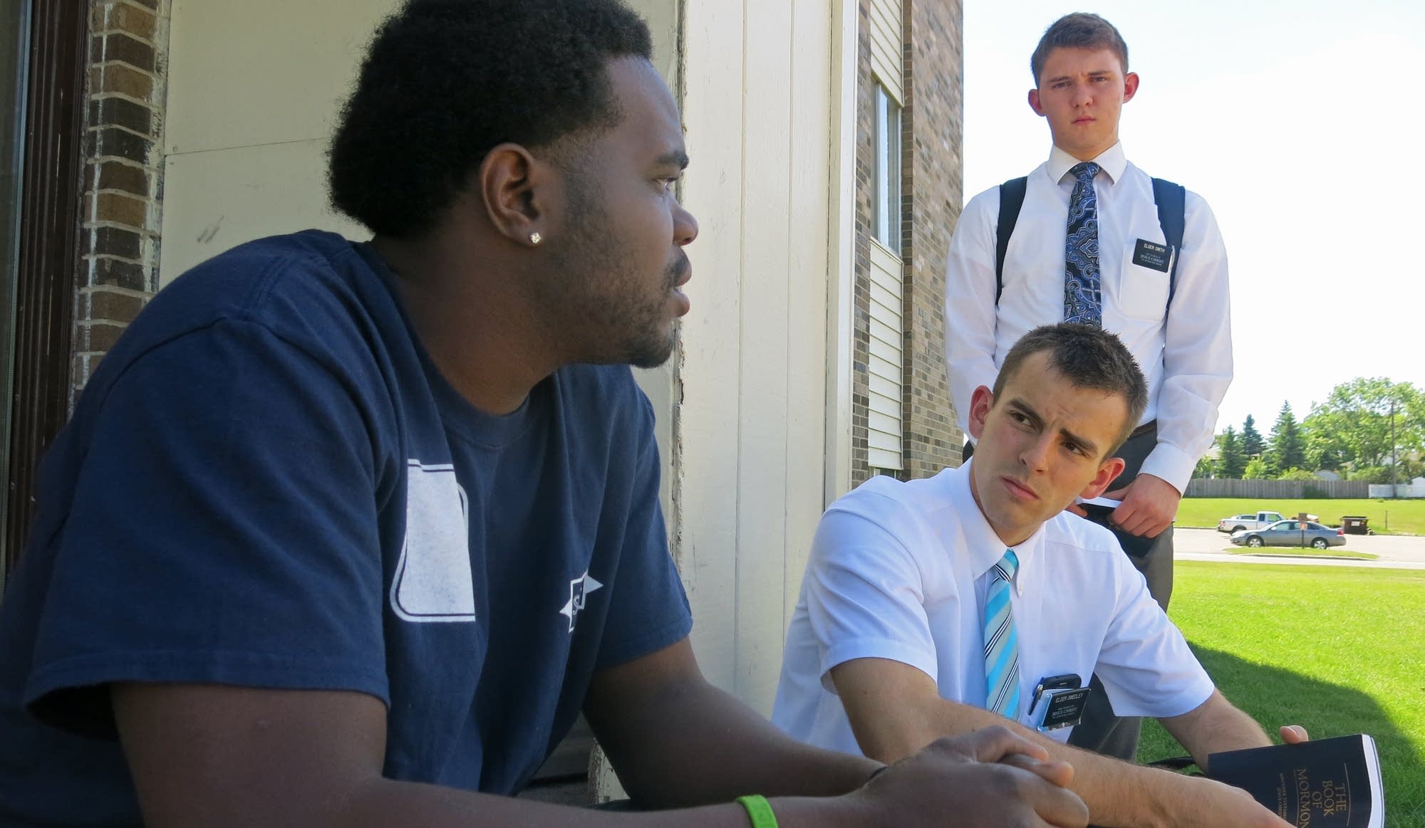 Young Mormon missionaries talk with a man identified only as Devontae.