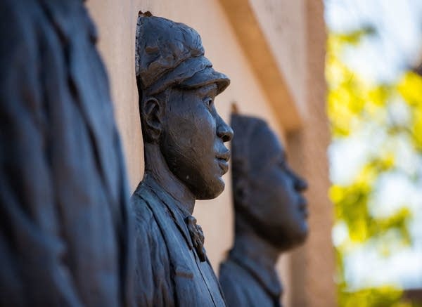 Sculpture of three people in relief. 