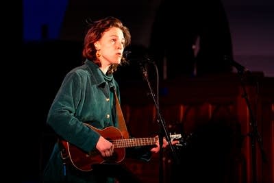 Woman singing and playing guitar