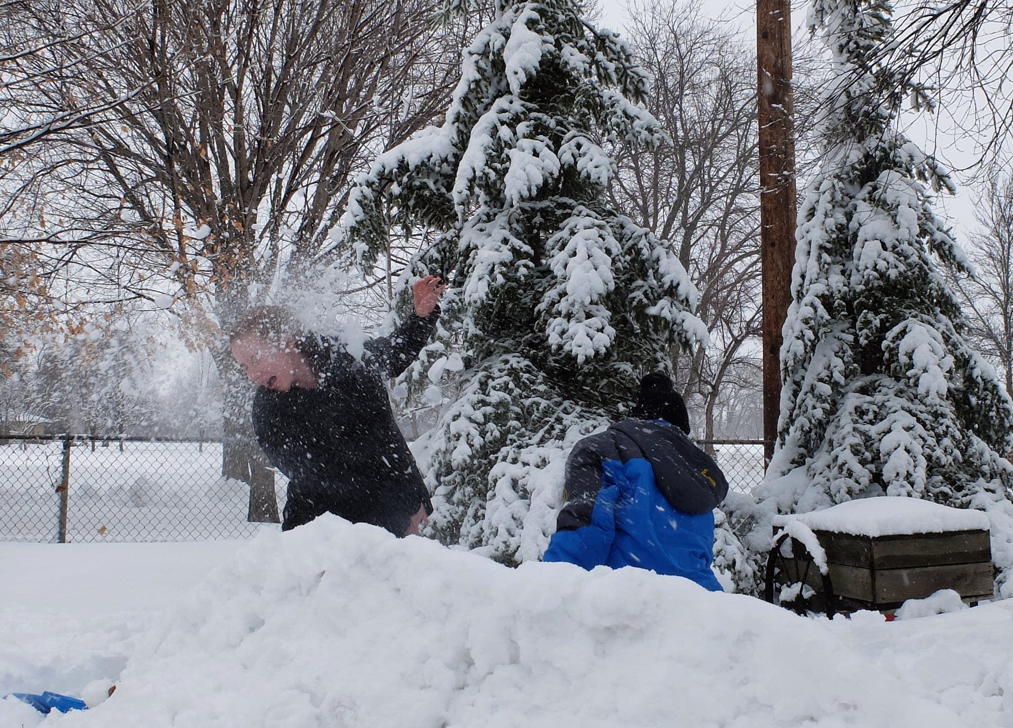 Hunter Wachenheim hits his sister Ellie with a snowball Monday.