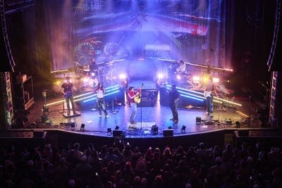 A band performing onstage in a large music venue