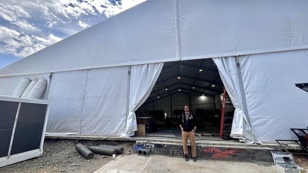 Mark Oliver, owner of Foundation Woodworks, stands in front of his temporary tent location in River Arts District in Asheville, North Carolina. 