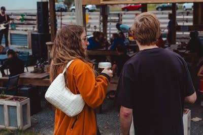 People gather and converse at a social event at a craft brewery