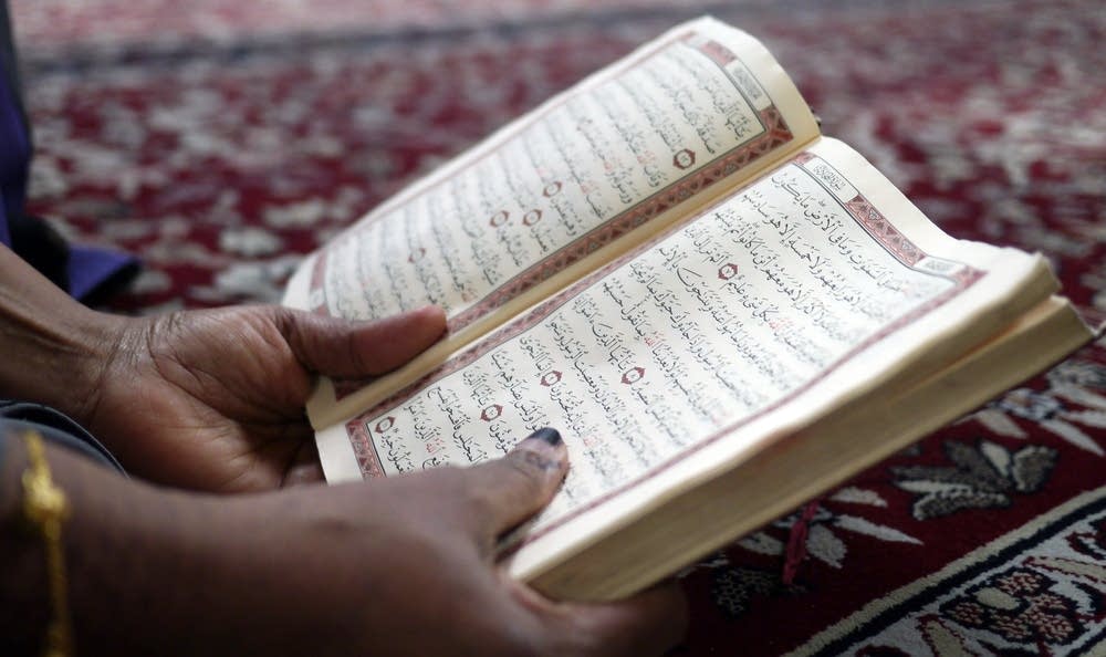 A woman reads the Quran during Friday prayers.