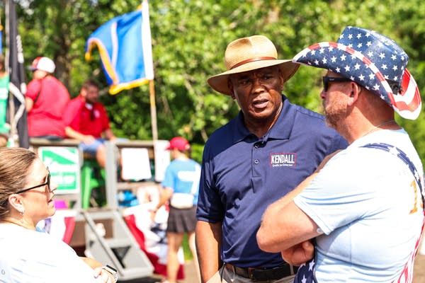 Two people with hats on talking at July 4 celebration