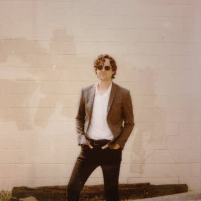 A man standing in front of a painted cinderblock wall