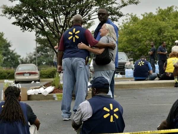Walmart employees gather in a nearby parking lot after a shooting.