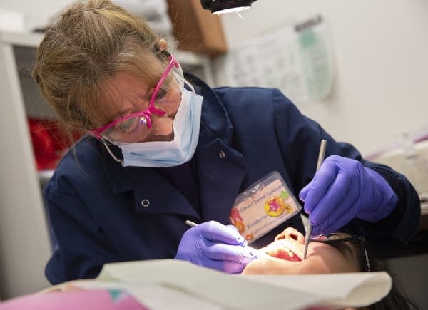 Dental hygenist Kimberly Bednar performs a check up on a student.