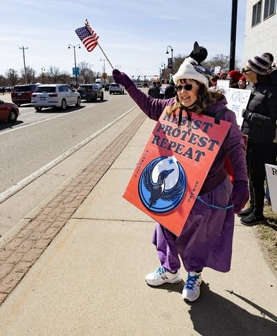 A person waves a flag during a protest with the rebel loon