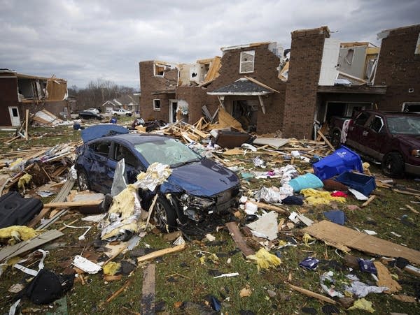 A car sits in the debris left behind by a tornado