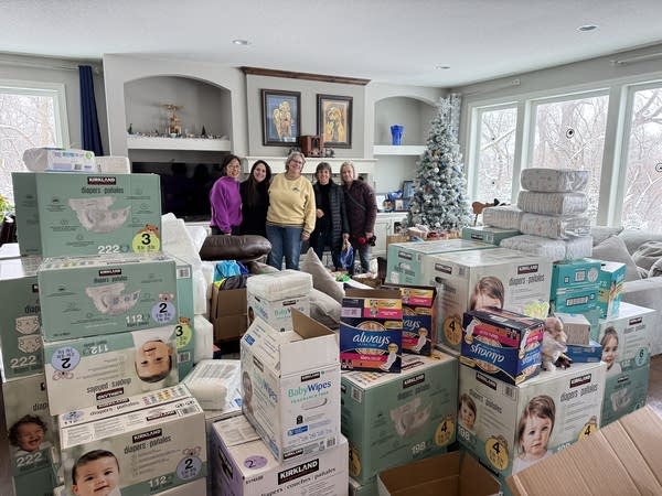 Women stand in a room with donations