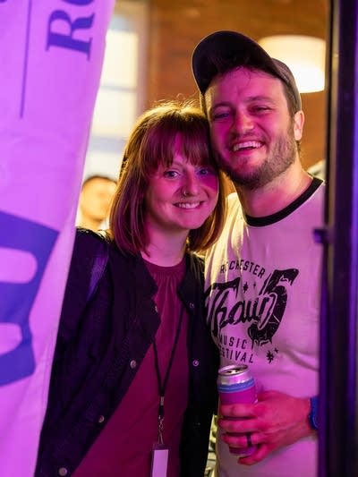 Two people stand together for a casual portrait at a music festival