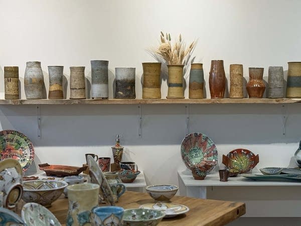 A shelf full of pottery.