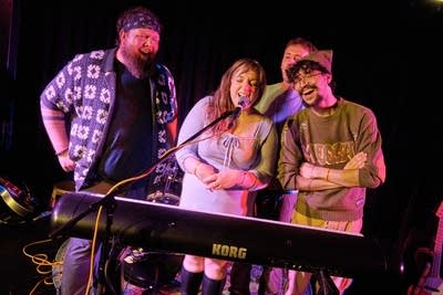 Four musicians performing onstage