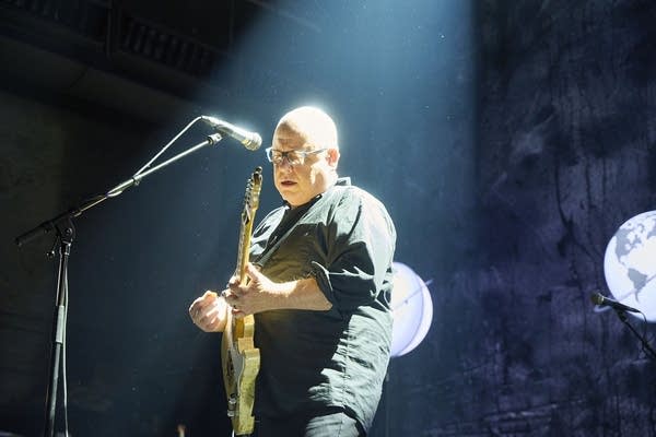 a man with a guitar performing on stage