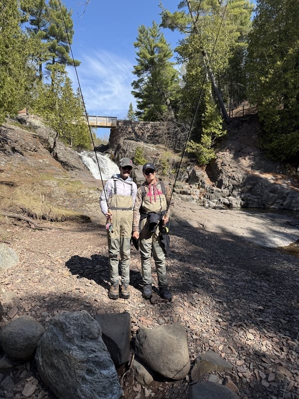 Two people holding fishing rods 
