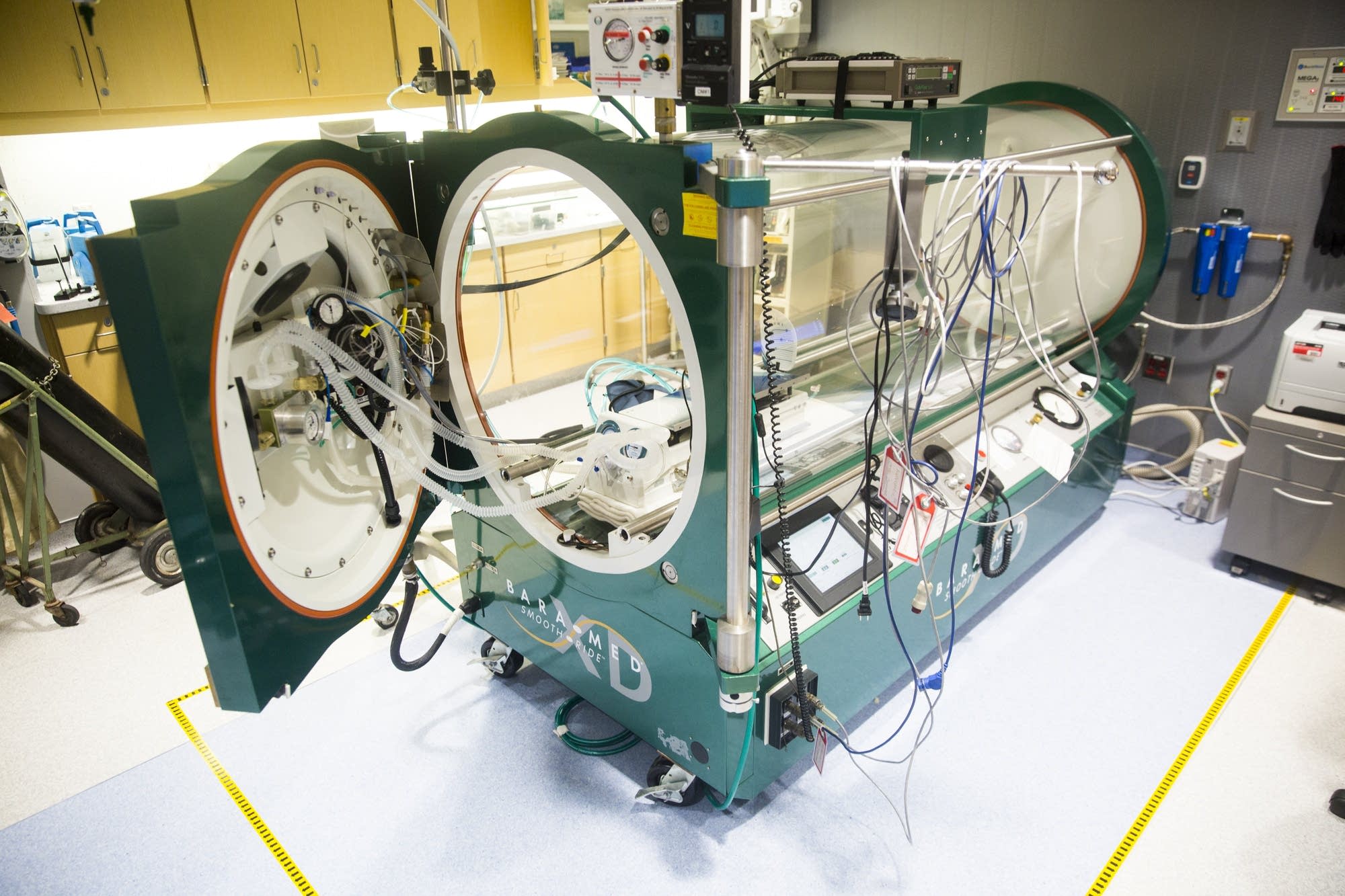 A monospace hyperbaric chamber sits empty.