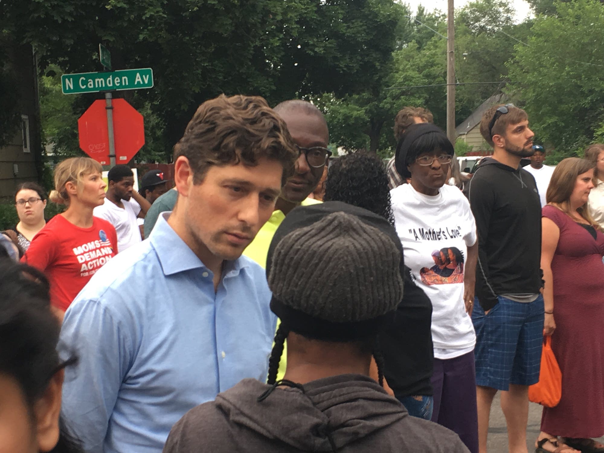 Mayor Jacob Frey talks with a woman attending a vigil.
