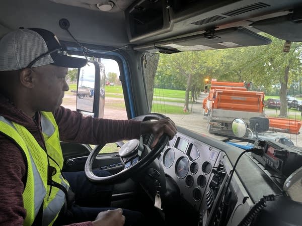 A man drives the wheel in a truck.