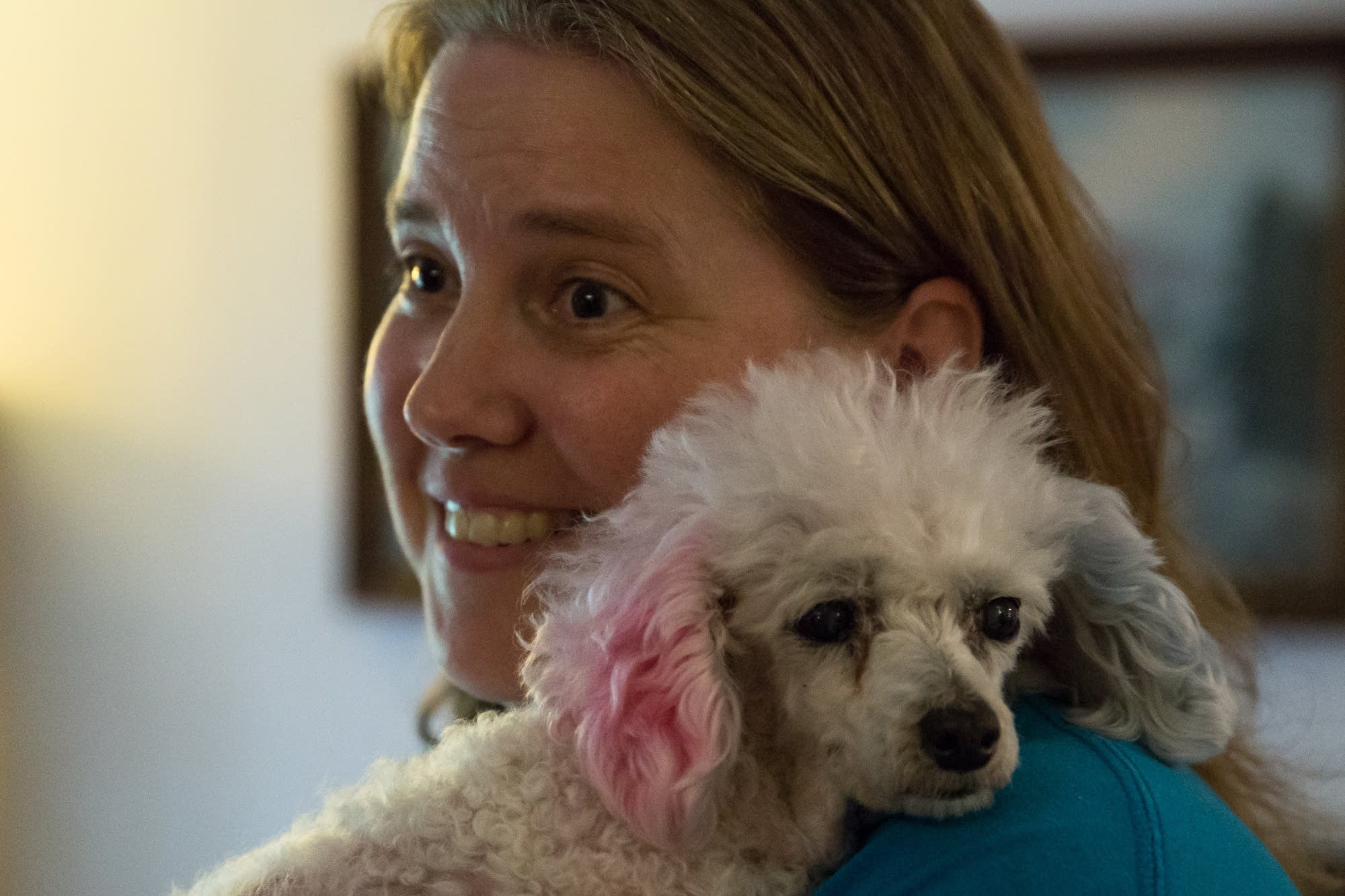 Eileen Hill, one of Peanut's owners, snuggles with her in the family room.