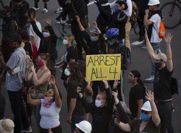 People holding signs as they stand in the interstate. 